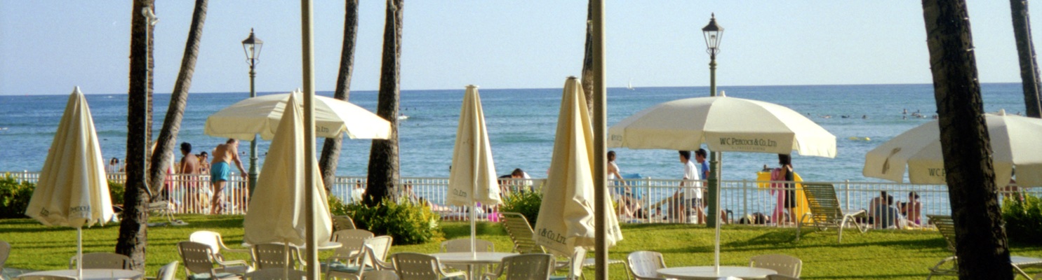 Photo taken from a holiday resort looking towards the crowd of people on the beach.
